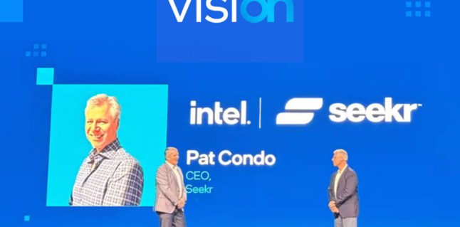 Seekr CEO Pat Condo speaking at Intel Vision event standing in front of a large blue screen